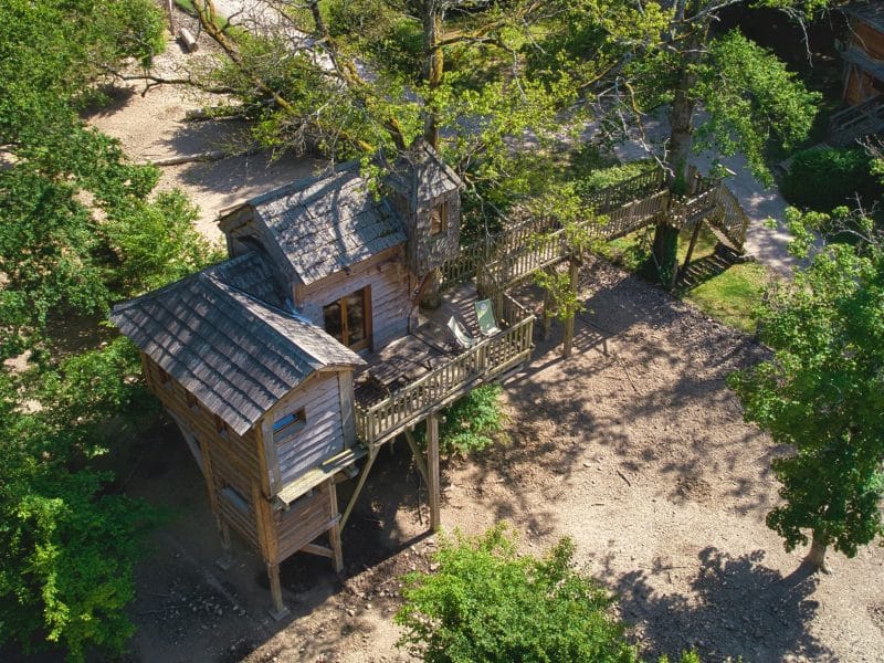 Cabane dans les arbres en Auvergne-Rhône-Alpes, perchée au milieu des feuillages verdoyants.