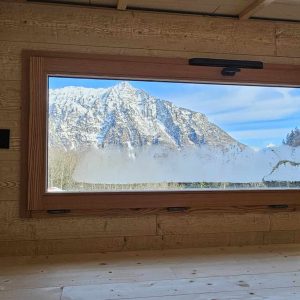 Cabane en bois avec vue panoramique sur les montagnes enneigées.