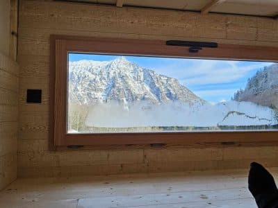 Cabane en bois avec vue panoramique sur les montagnes enneigées.