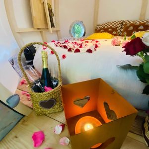 Hébergement insolite en Bretagne : chambre romantique avec pétales de roses et champagne.