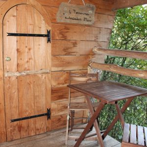Cabane en bois dans les Pays de la Loire, avec une porte en bois et une terrasse en bois.