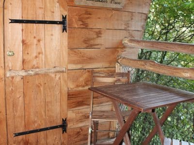 Cabane en bois dans les Pays de la Loire, avec une porte en bois et une terrasse en bois.