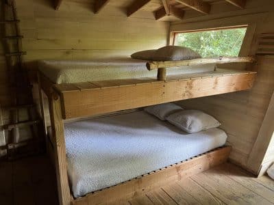 Chalet en bois avec lits superposés, ambiance chaleureuse et naturelle.
