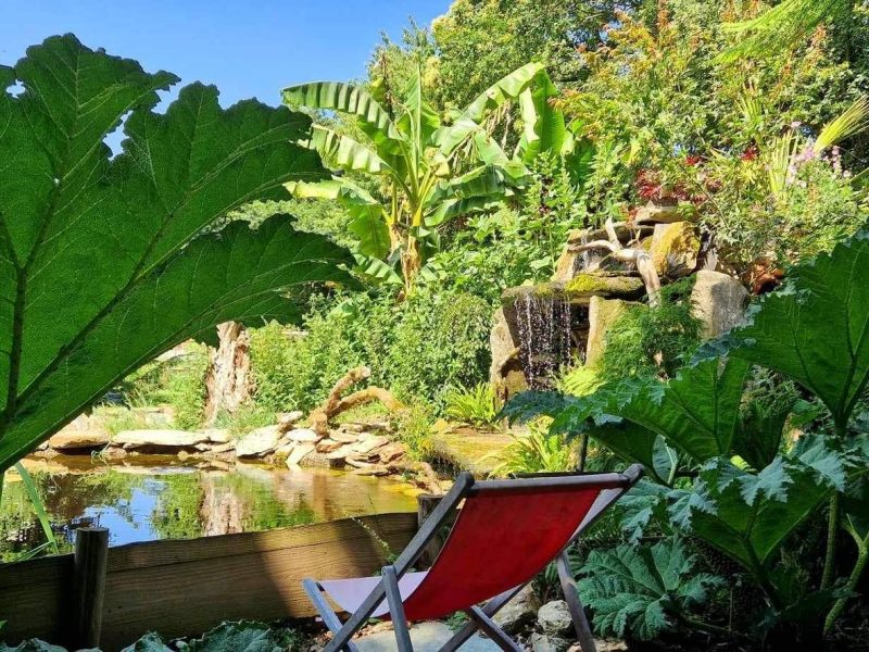 Chalet en pleine nature, avec un jardin luxuriant et un étang paisible.