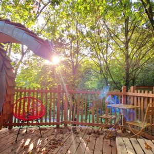 Hébergement insolite en Bretagne : cabane en bois avec terrasse et vue sur la forêt.
