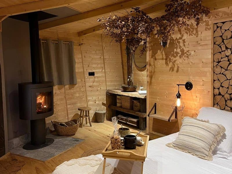 Chalet en bois chaleureux avec cheminée, décoré de touches naturelles et confortables.