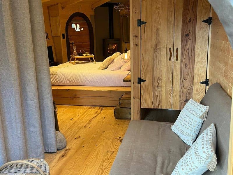 Cabane en bois chaleureuse avec un lit douillet et des touches décoratives.