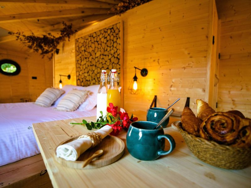 Chalet en bois chaleureux avec petit-déjeuner gourmand sur la table.