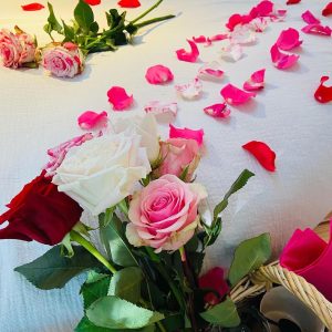 Chambre romantique en Bretagne, décorée de roses et pétales sur le lit.