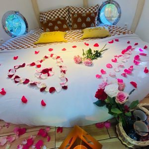 Hébergement insolite en Bretagne : chambre romantique décorée de pétales de roses.