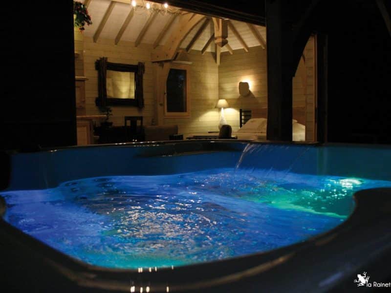 Chalet cosy avec jacuzzi lumineux, offrant une ambiance relaxante et chaleureuse.