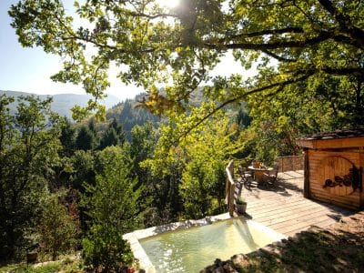 Cabane en bois avec terrasse et vue panoramique sur la nature en Auvergne-Rhône-Alpes.