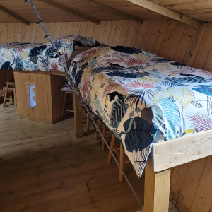 Chalet en bois avec lits superposés, décoré de motifs tropicaux colorés.