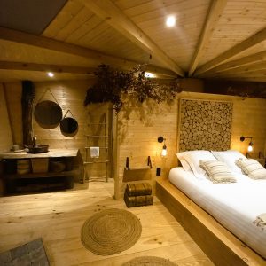 Chalet en bois chaleureux avec lit douillet et décoration naturelle. Parfait pour se ressourcer.