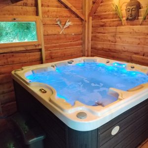 Hébergement insolite en Aquitaine avec jacuzzi lumineux dans un chalet en bois.
