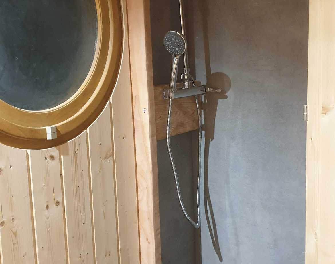 Douche moderne en bois dans un hébergement insolite en Auvergne-Rhône-Alpes.