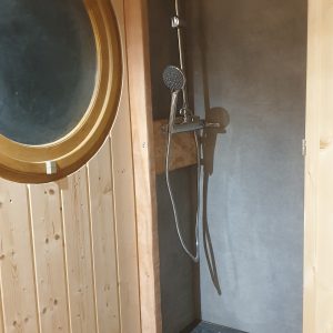 Douche moderne en bois dans un hébergement insolite en Auvergne-Rhône-Alpes.