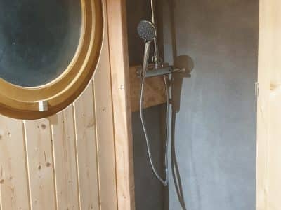 Douche moderne en bois dans un hébergement insolite en Auvergne-Rhône-Alpes.