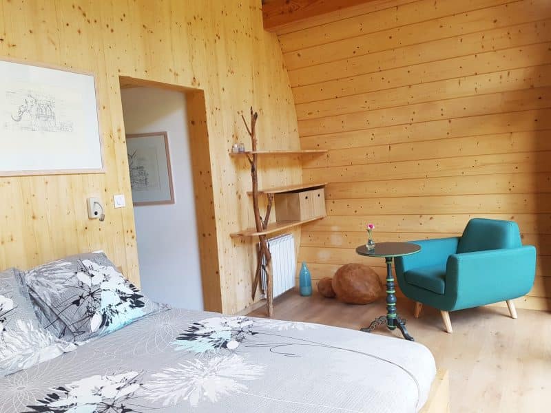 Chalet en bois chaleureux avec lit douillet et coin salon moderne.
