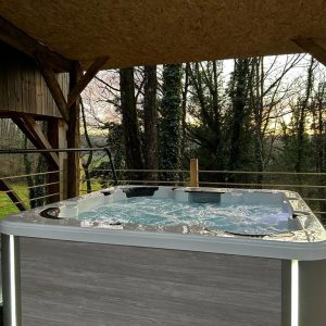Hébergement insolite en Limousin avec jacuzzi extérieur, entouré de verdure.