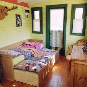 Hébergement insolite en Bourgogne : charmante cabane avec lit douillet et décor coloré.