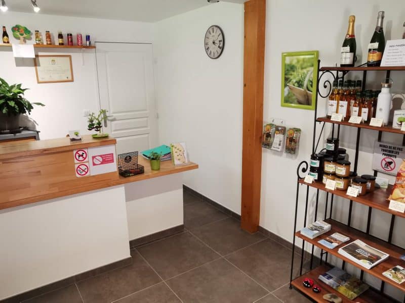 Réception dun gîte accueillant, avec étagère de produits locaux et boissons.