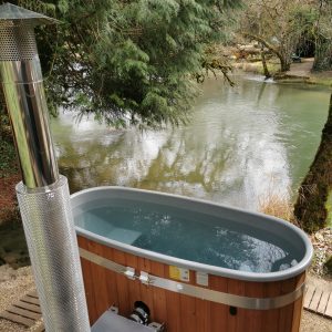 Bain nordique en bois au bord dun étang, idéal pour une escapade en Bourgogne.