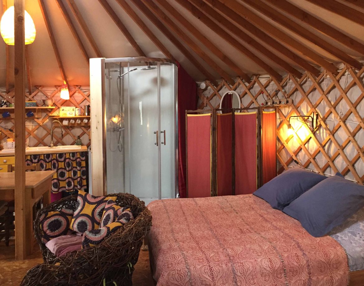Yourte confortable en Auvergne, avec lit douillet et salle de douche moderne.