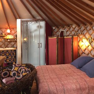 Yourte confortable en Auvergne, avec lit douillet et salle de douche moderne.