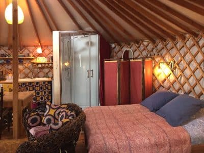 Yourte confortable en Auvergne, avec lit douillet et salle de douche moderne.
