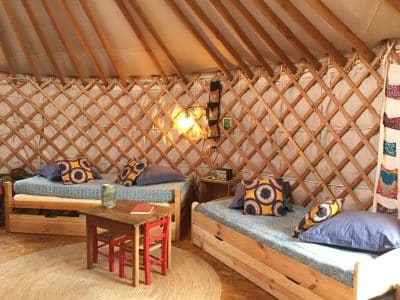 Yourte confortable en Auvergne, avec lits douillets et décor coloré.