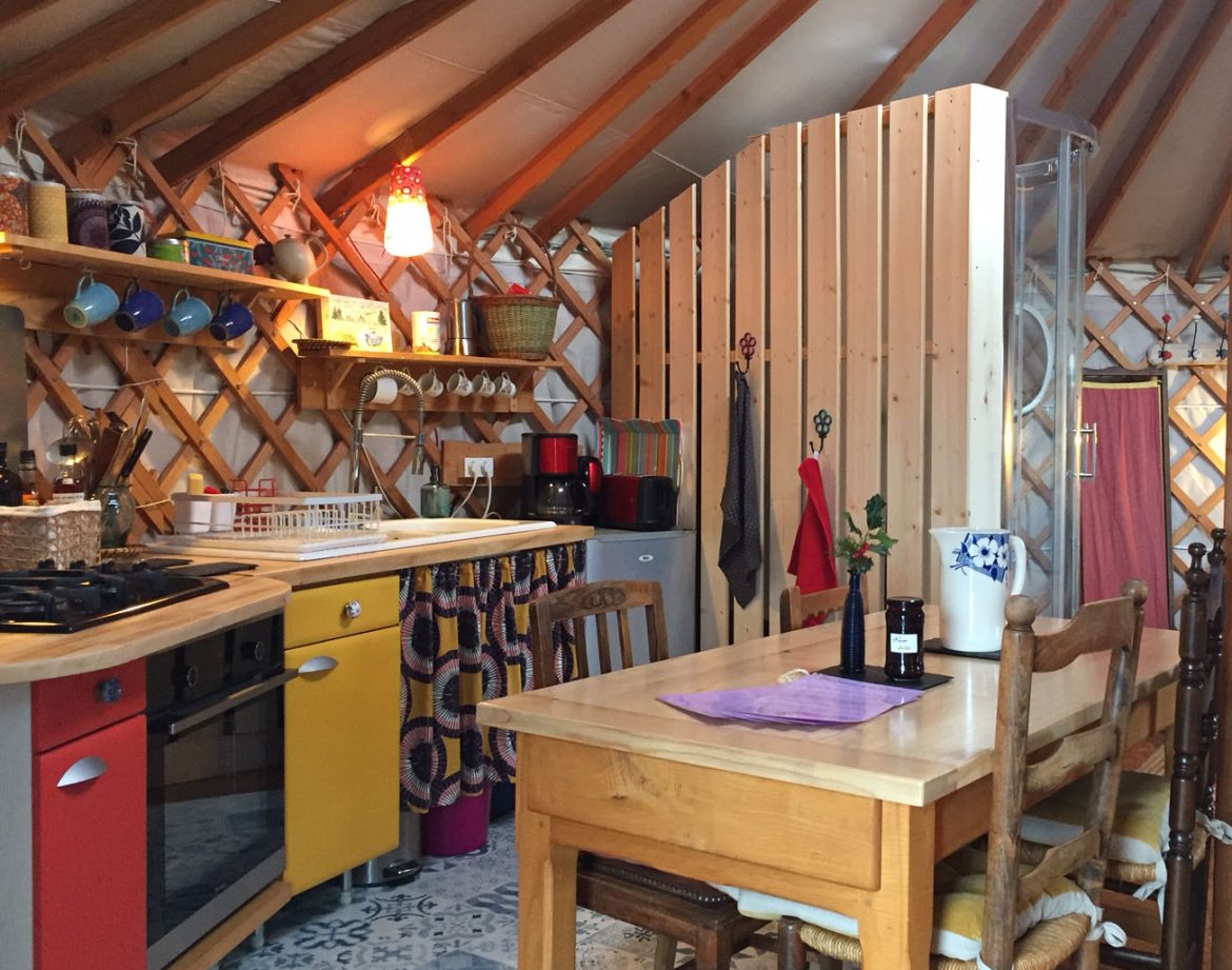 Yourte cosy en Auvergne, avec une cuisine colorée et un décor chaleureux.