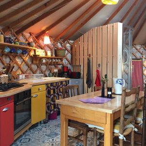 Yourte cosy en Auvergne, avec une cuisine colorée et un décor chaleureux.