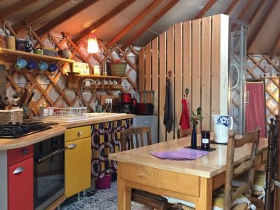 Yourte cosy en Auvergne, avec une cuisine colorée et un décor chaleureux.