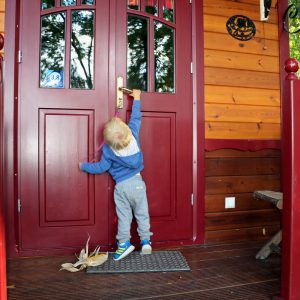 Cabane en bois colorée à Champagne-Ardenne, enfant devant la porte dentrée.