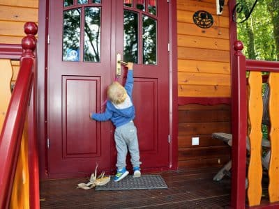 Cabane en bois colorée à Champagne-Ardenne, enfant devant la porte dentrée.