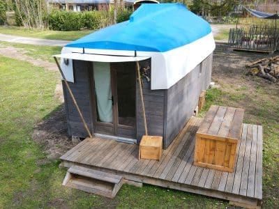 Hébergement insolite en forme de bateau à Champagne-Ardenne, avec terrasse en bois.