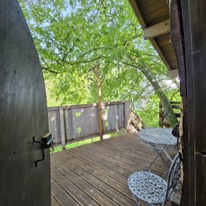 Cabane perchée en Hauts-de-France avec terrasse en bois et vue sur la nature.