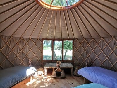 Yourte spacieuse en Provence-Alpes-Côte dAzur, avec un plafond vitré et des lits confortables.