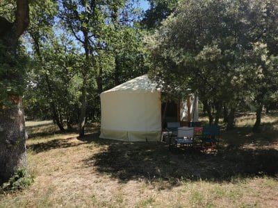 Yourte spacieuse en pleine nature, entourée darbres, idéale pour un séjour paisible.