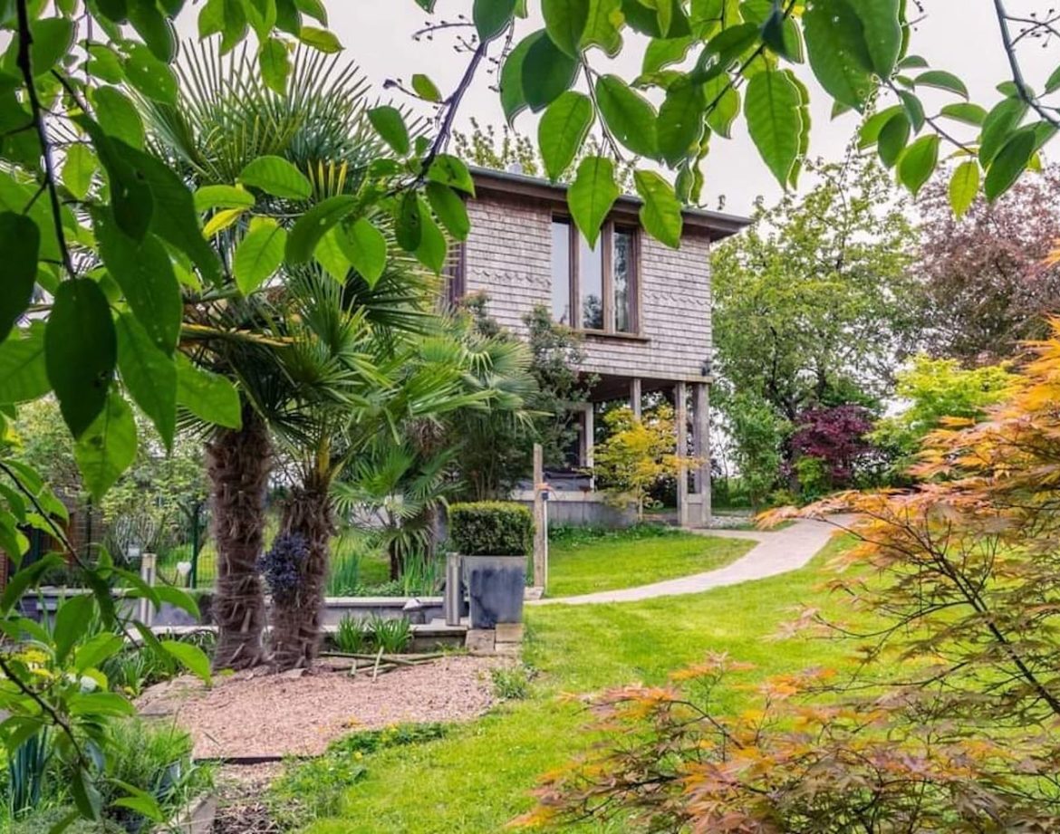Cabane moderne entourée de verdure, avec un jardin coloré à Hauts-de-France.
