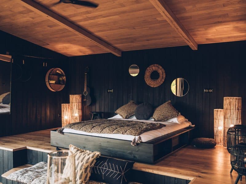 Chalet moderne avec lit king-size, ambiance chaleureuse et décoration en bois.