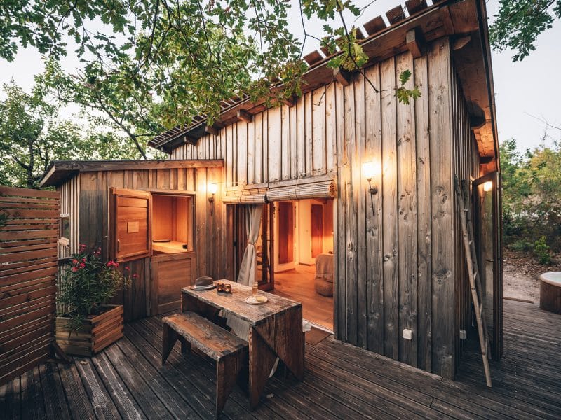 Cabane en bois dans les Midi-Pyrénées, avec terrasse et spa extérieur.