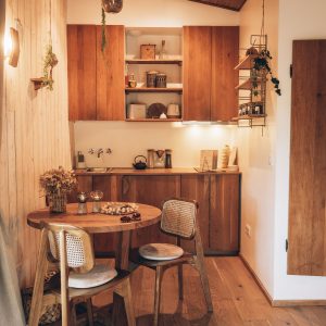 Hébergement insolite en Midi-Pyrénées, avec cuisine en bois et table ronde accueillante.