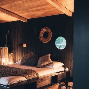 Chalet en bois avec lit douillet, éclairage tamisé et décor chaleureux à Midi-Pyrénées.