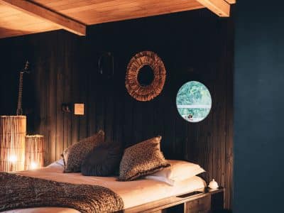 Chalet en bois avec lit douillet, éclairage tamisé et décor chaleureux à Midi-Pyrénées.