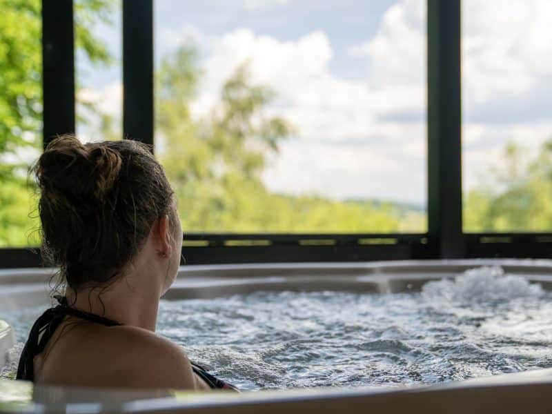Hébergement insolite à Limousin : jacuzzi avec vue sur la nature verdoyante.