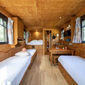 Hébergement insolite en bois à Champagne-Ardenne, intérieur chaleureux avec lits confortables.