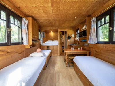 Hébergement insolite en bois à Champagne-Ardenne, intérieur chaleureux avec lits confortables.
