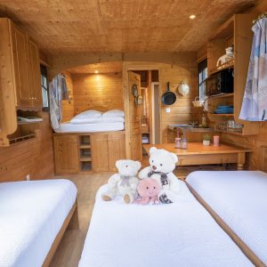 Hébergement insolite en Auvergne : cabane en bois avec lits jumeaux et peluches.